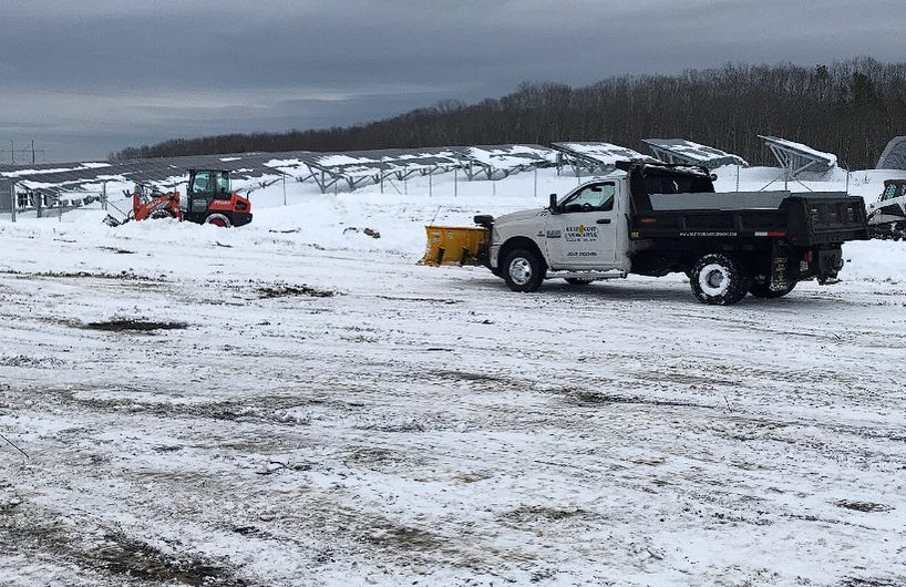 Loader relocating snow piles on a commercial property